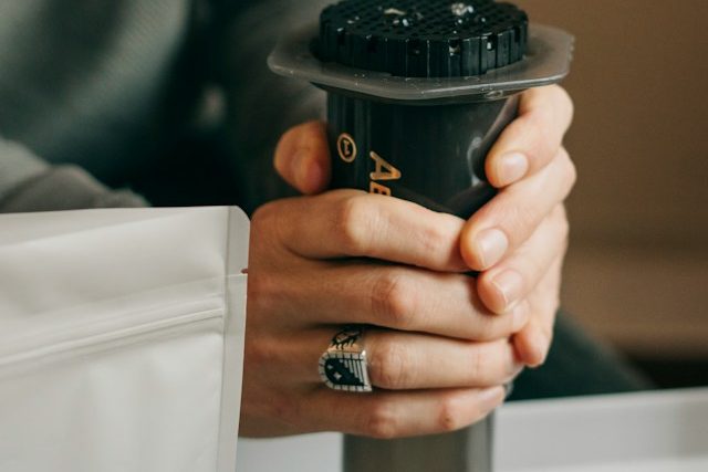 エアロプレスを両手で押して、コーヒーを抽出しているところ